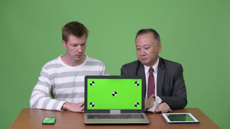 熟成した日本人ビジネスマンと若いスカンジナビア人ビジネスマンが一緒に働いています