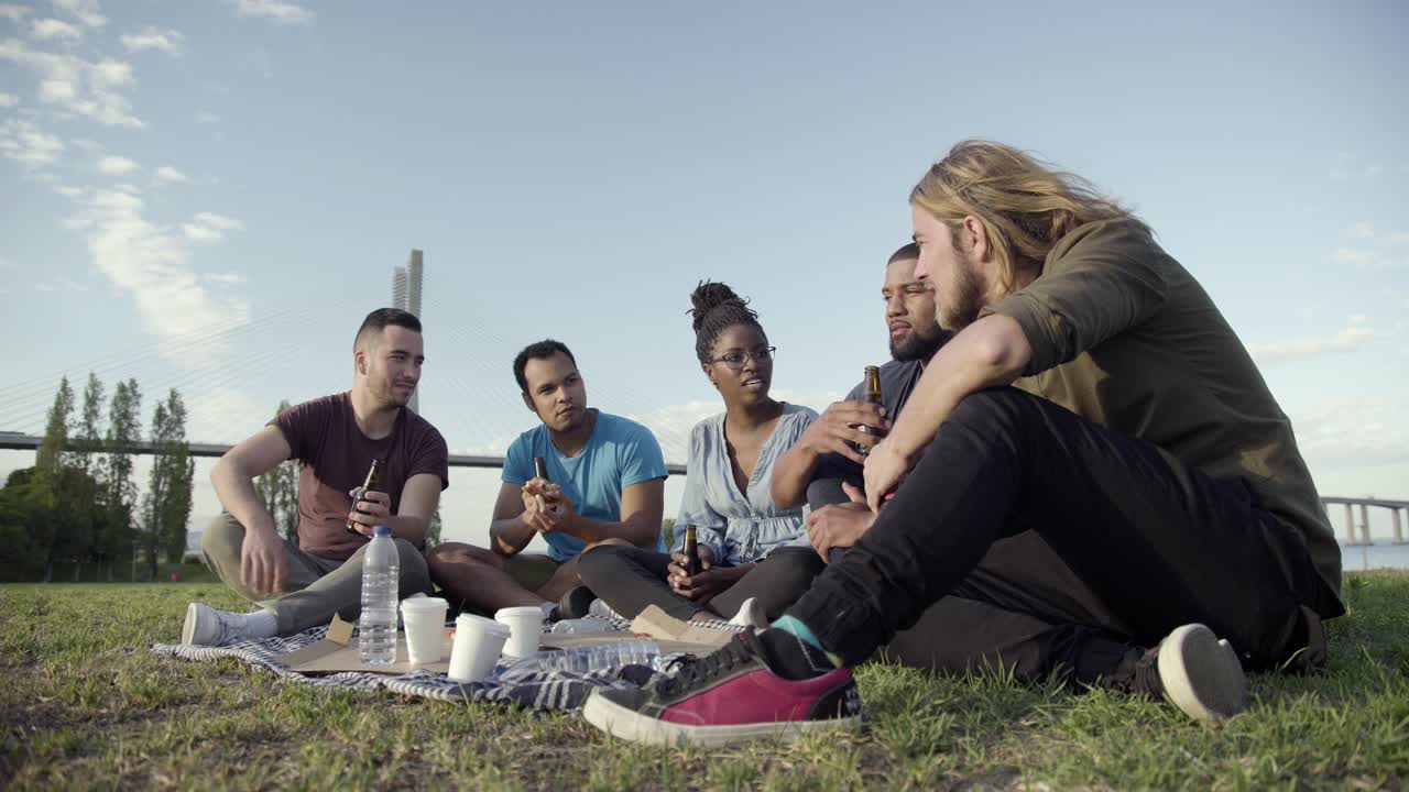 미소 짓는 사람 들 이 피크닉 도중 즐거운 대화 를 하고 있다