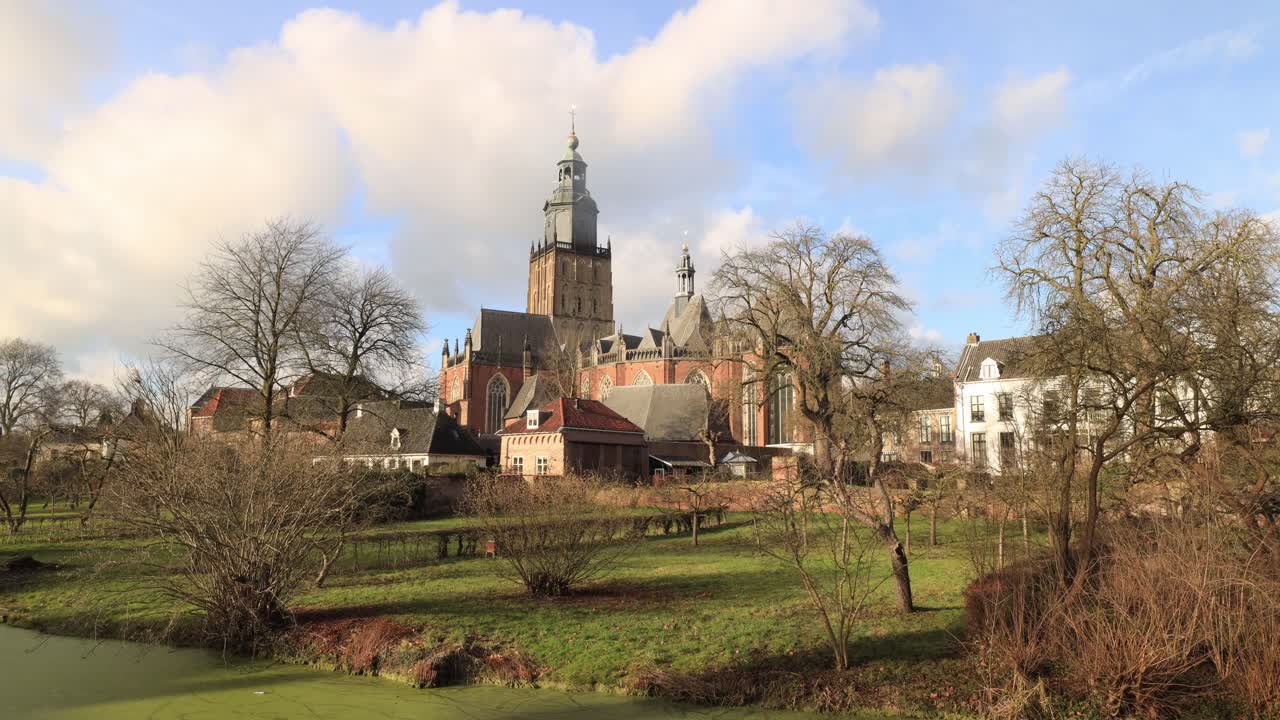 네덜란드 유서 깊은 도시 zutphen의 전경에 있는 무성한 정원에서 패턴을 만드는 walburgiskerk의 그림 같은 중세 교회 탑 위를 지나가는 구름과 함께 도시 경관 시간 경과
