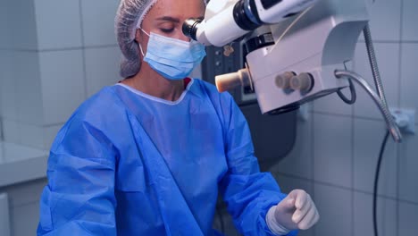 female doctor during laser eye surgery. ophthalmologist performs an operation on eye with the help of microscope in clinic.