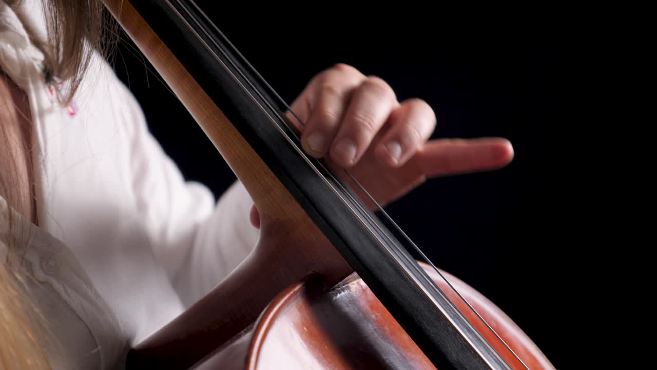 年輕的女性音樂家在音樂會或音樂會上演奏古典音樂的大提琴或大小提琴 慢慢地和優雅地觸摸弦 練習大表演 4k 50fps