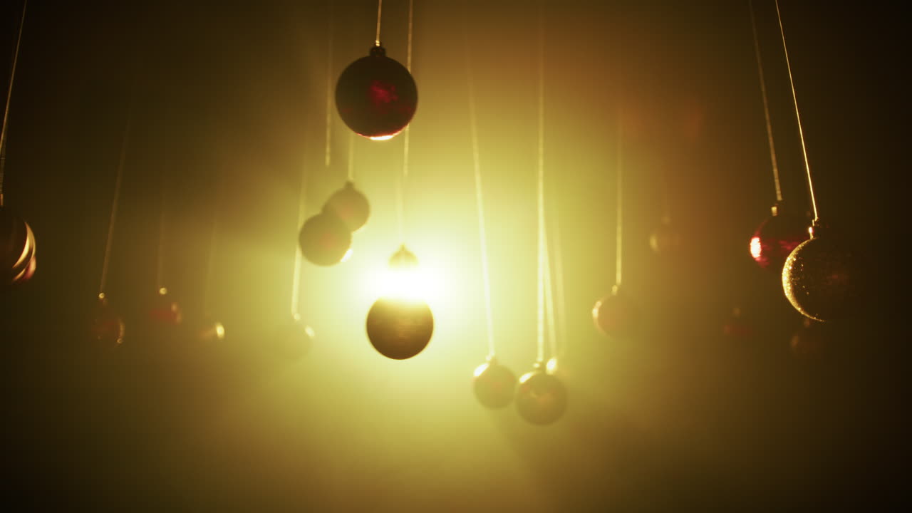 Dancing Christmas balls hanging from wire with bright yellow backlight