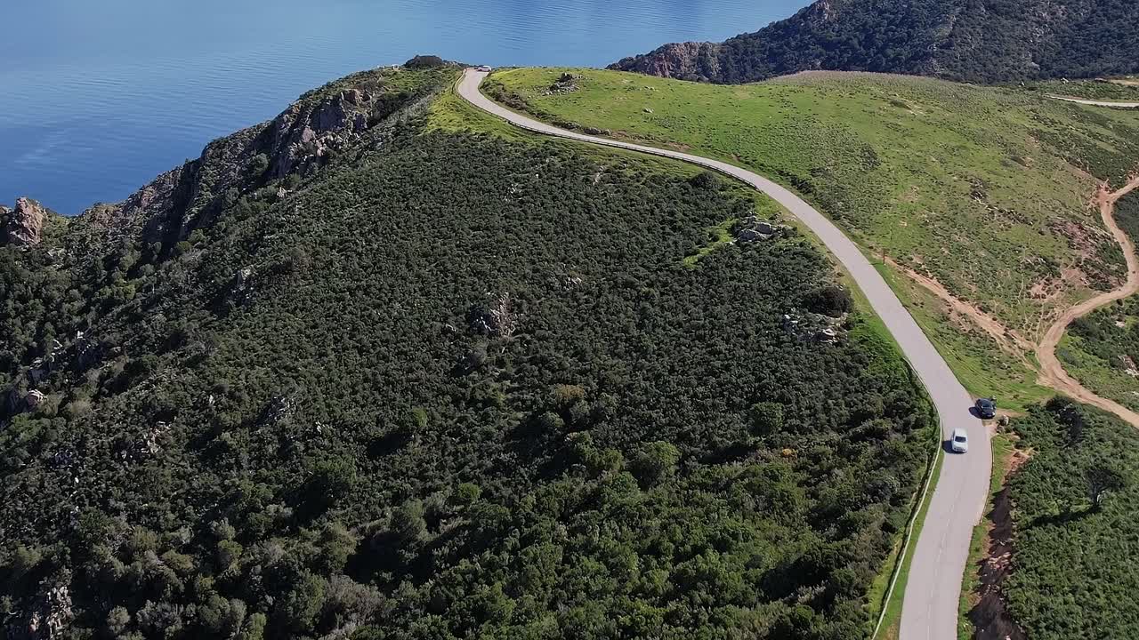 Strada panoramica serpeggia tra le verdi colline vicino alla costa in Corsica, Francia