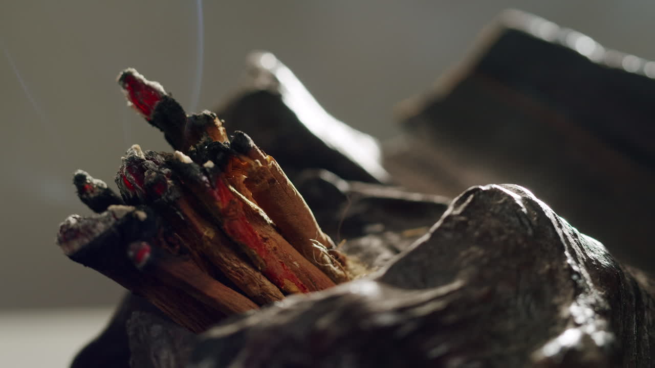 Person holding Palo Santo wood stick in hand, aromatic Palo Santo burning on black background, smoke spreading around, slow motion video clip, high quality 4k close up footage. High quality 4k footage