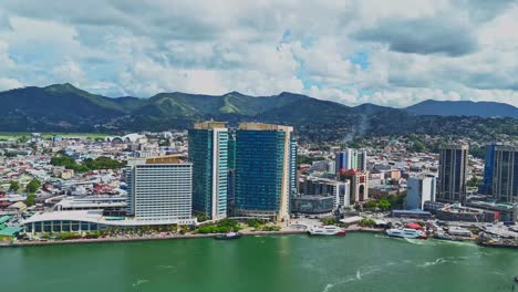 timelapse aerial view of the city of port of spain, trinidad and tobago with a mountain range in the background