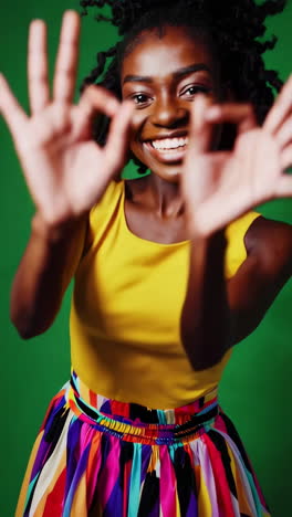 happy african american woman making ok gesture on green screen