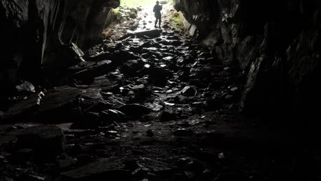 persona explorando la entrada de una cueva oscura
