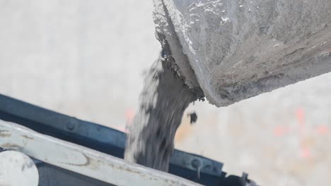 concrete pours from the pipe of concrete mixer - close up