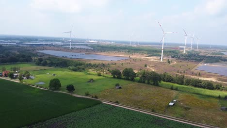 aerial above agricultural fields and industrial wind and solar farms in belgium