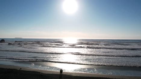 Scorching-heat-and-silhouettes-of-a-couple-on-Coastal-Ruby-Beach,-Washington