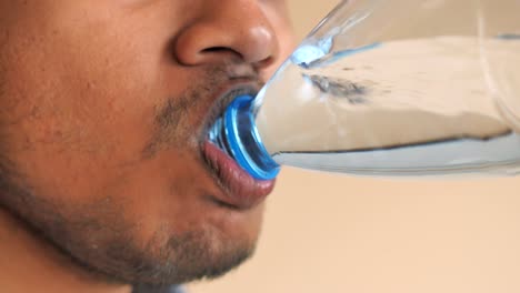 man drinking water from a plastic bottle