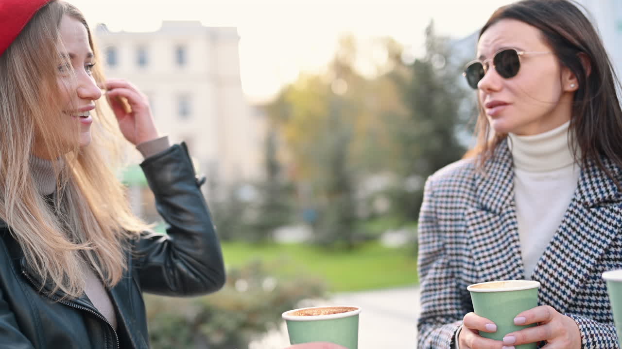 Two women talking and drinking coffee at a terrace