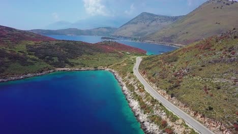 Coastal-road-travelling-through-the-stunning-Porto-Palermo-on-the-Albanian-Riviera,-Eastern-Europe