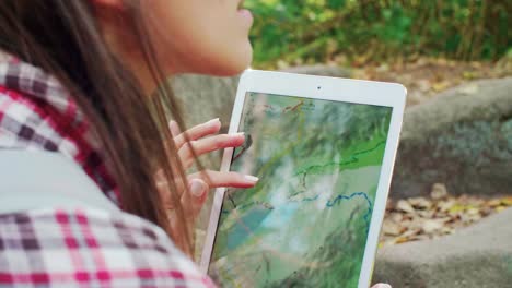 Part-of-woman-using-a-tablet-during-hiking-trip