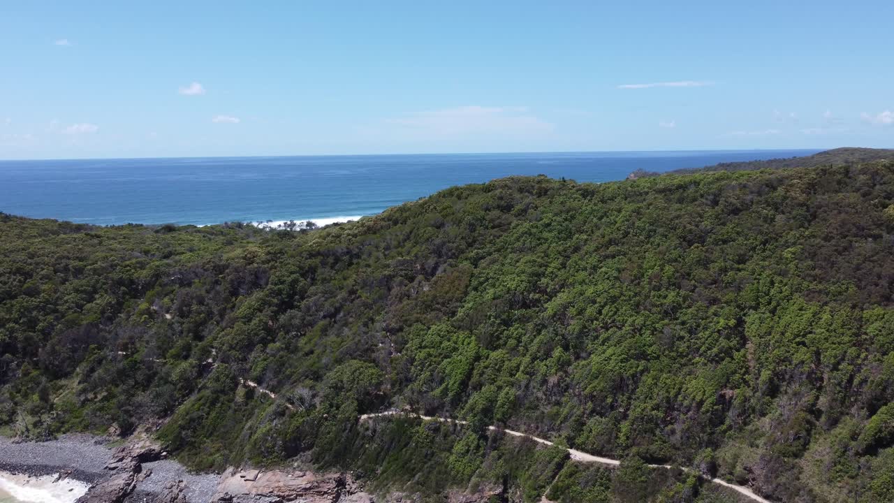 반도 반대편에 있는 해안선, 산책로, 해변을 보여주는 드론 상승