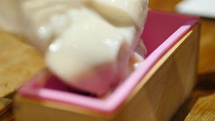 Pouring coconut soap into mold at thick trace