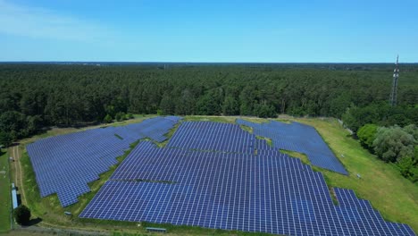 photovoltaic panels providing clean energy in a solar farm on hill near a forest in germany. perfect aerial view flight panorama orbit drone
