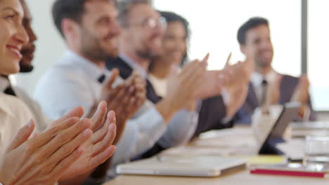 empresarios alrededor de la mesa de la sala de juntas aplauden la presentación