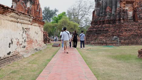 group of tourists walking around ancient temple ruins