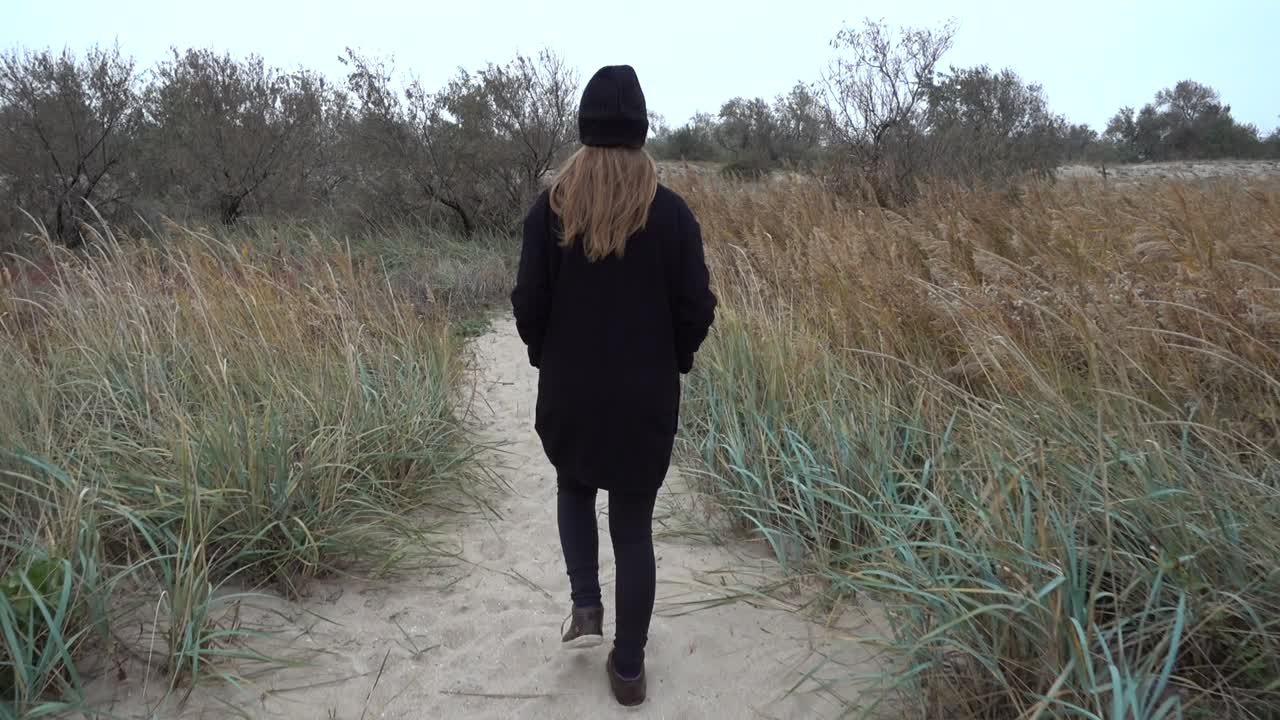 La jeune fille se promène sur un sentier. Tournage en automne