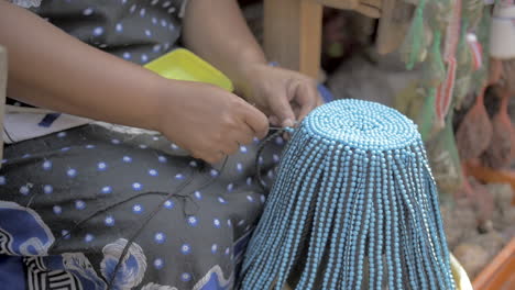 African-woman-trader-makes-beaded-sangoma-headpiece-for-sale-at-market