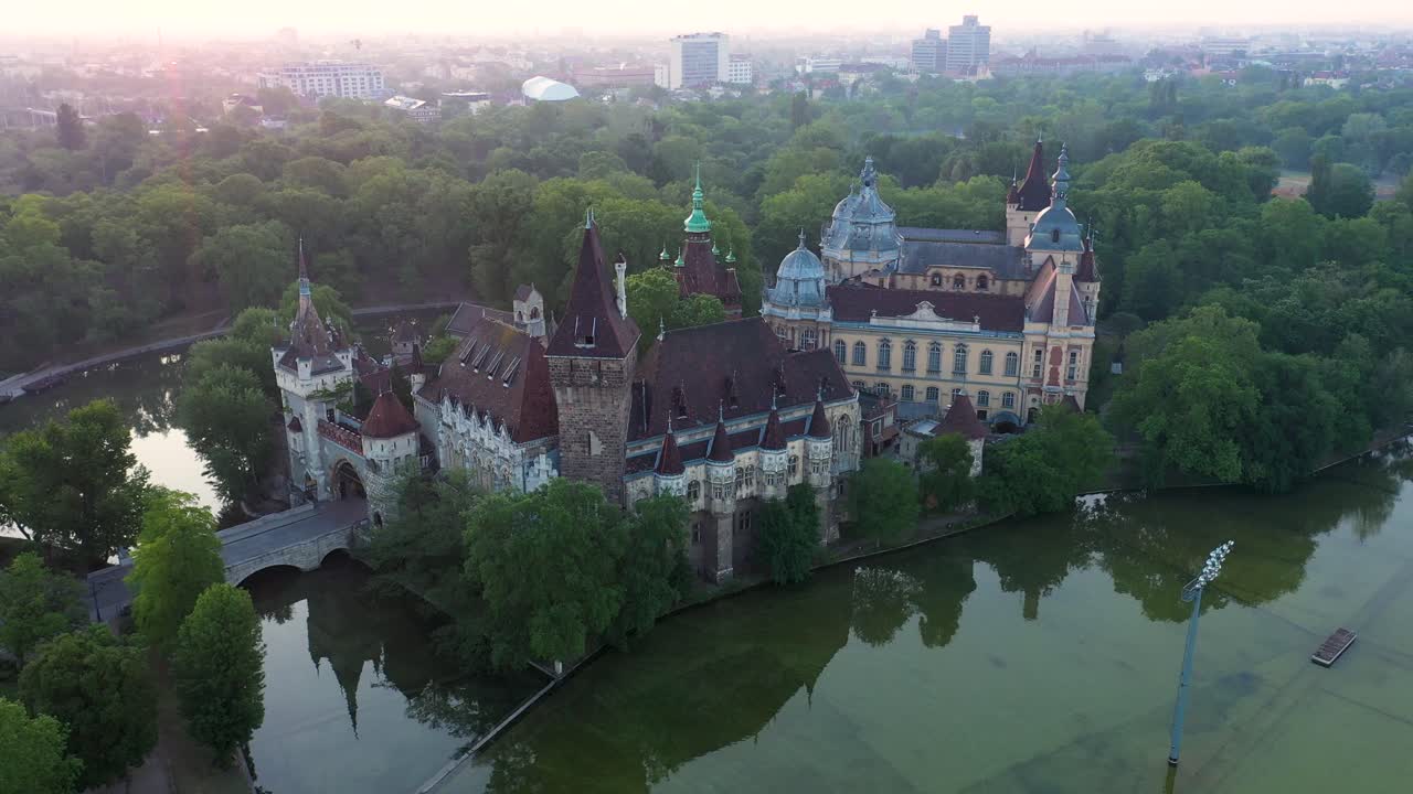 Drone footage from the Vajdahunyad castle at sunrise early morning in the empty Budapest. 
Drone circles slowly.