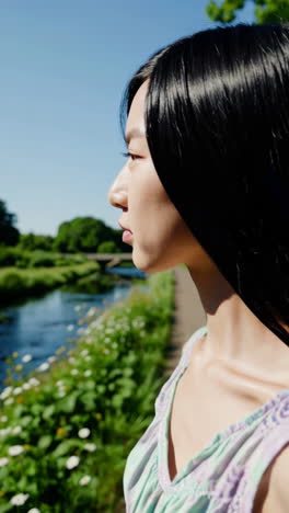 young woman profile in a park by a river
