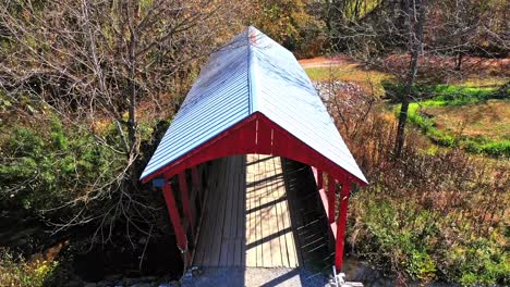 bridge with red picturesque wooden roof in an autumn forest