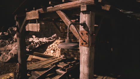 old rustic lantern hanging under a wooden structure at a mining site