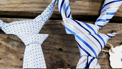 ties arranged with happy fathers day tag on wooden plank