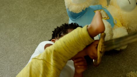 front view of cute little black boy playing and lying on floor of comfortable home 4k