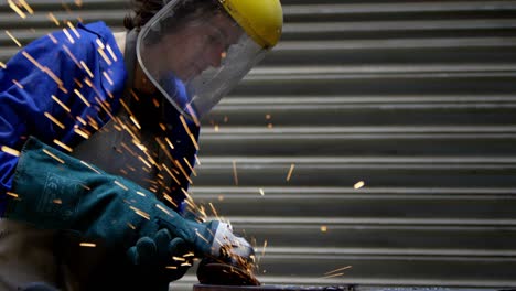 Female-welder-using-grinder-in-workshop-4k