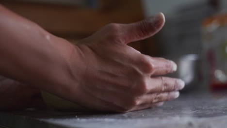 bola de masa suavemente redondeada en forma de bola a mano en una mesa de granito, filmada como una toma de cerca