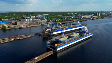 Moveble-ship-repair-dry-docks-with-vessels-inside-in-Riga-harbor,-aerial-view