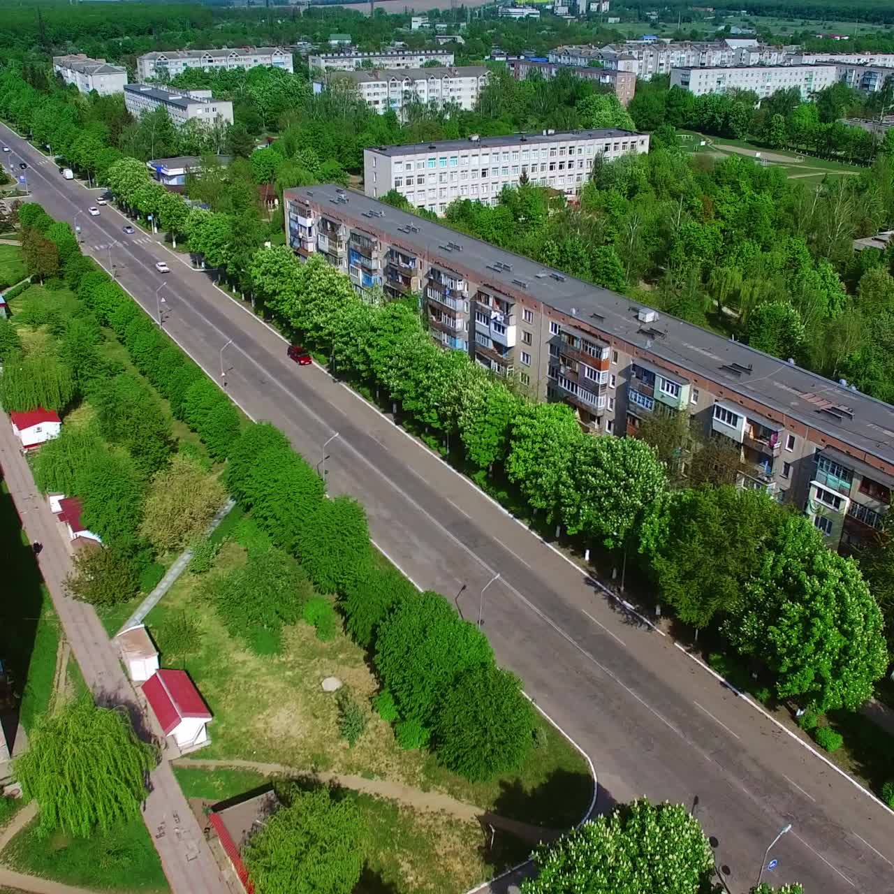 Sunny view of the provincial Ukrainian city on summer day. Residential urban districts full of greenery from aerial perspective