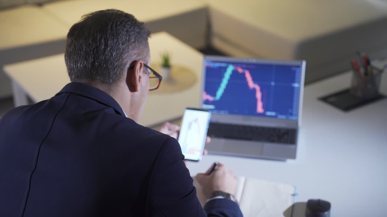 Man analyzing stock market and cryptocurrency charts from laptop.