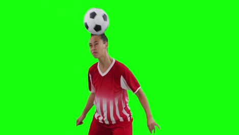 Video-of-caucasian-female-football-player-head-kicking-football-and-copy-space-on-green-screen