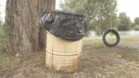 trash can lonely tire swing near riverbank in melnik, wide angle