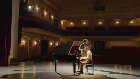 musicians playing violin and grand piano in concert hall