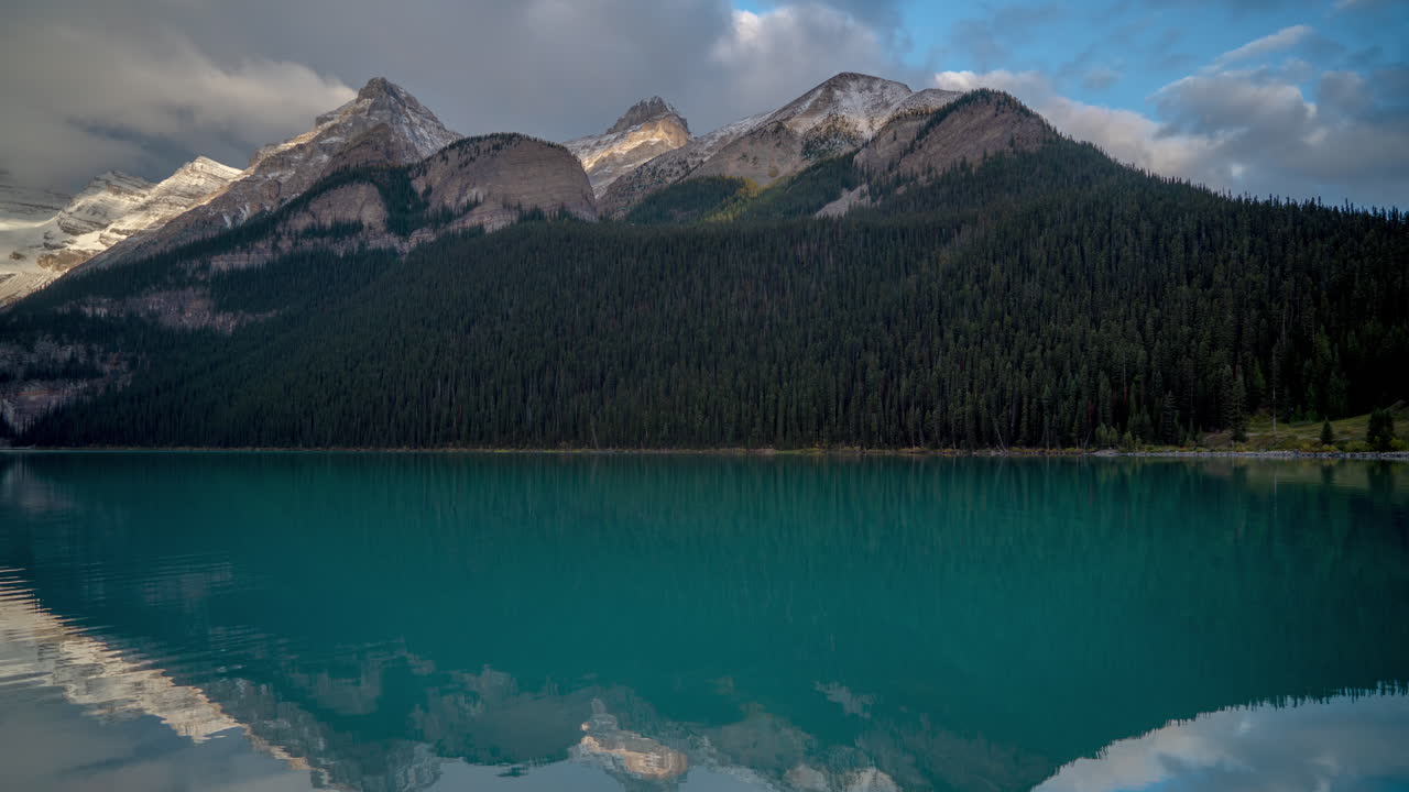 lapso de tiempo, agua glacial azul y nubes dramáticas sobre picos montañosos nevados