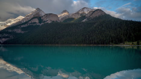 Time-lapse,-blue-glacial-water-and-dramatic-clouds-above-snow-capped-mountain-peaks