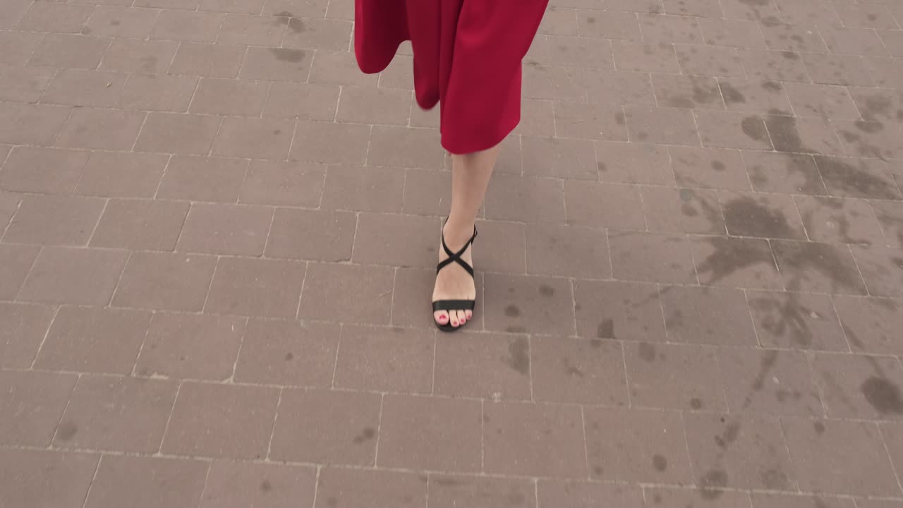 una chica bonita de rojo camina por la calle.