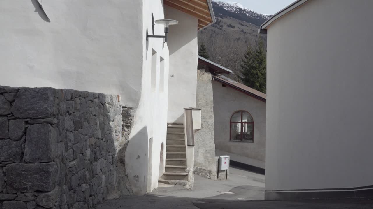 Narrow Street in a European Village with Mountain Background