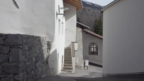 narrow street in a european village with mountain background