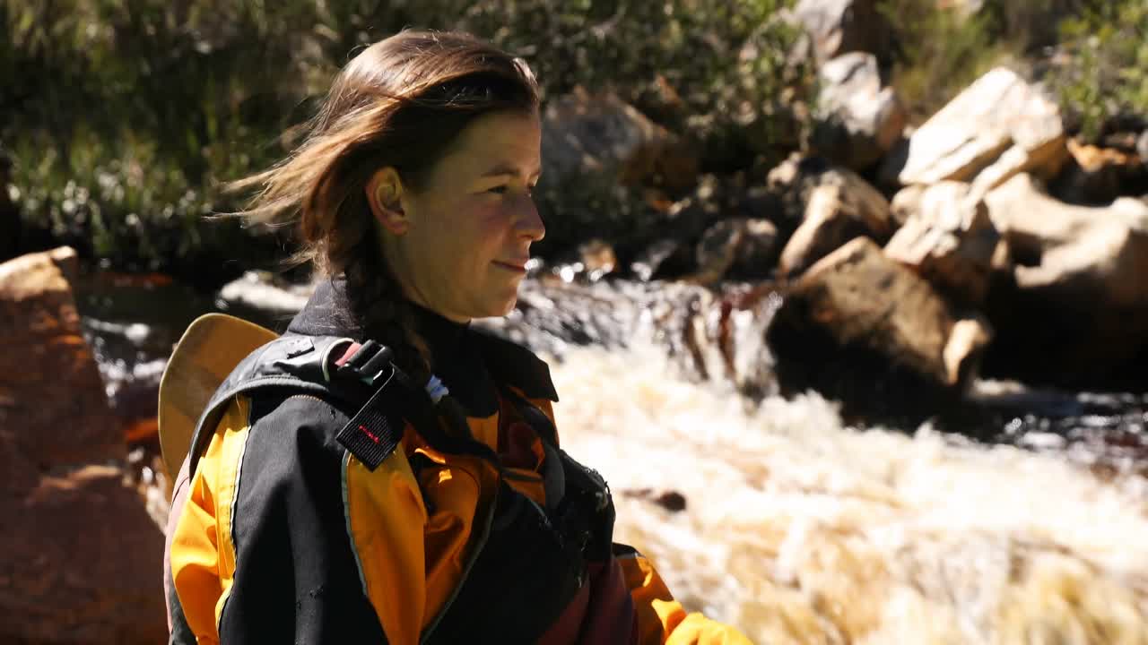 mujer preparándose para empezar a andar en kayak en el río 4k