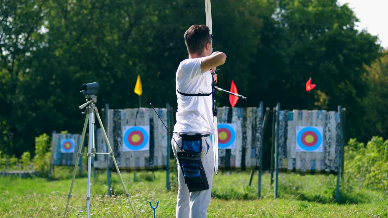 한 남자가 타을 가진 사격장에서 활을 습니다.