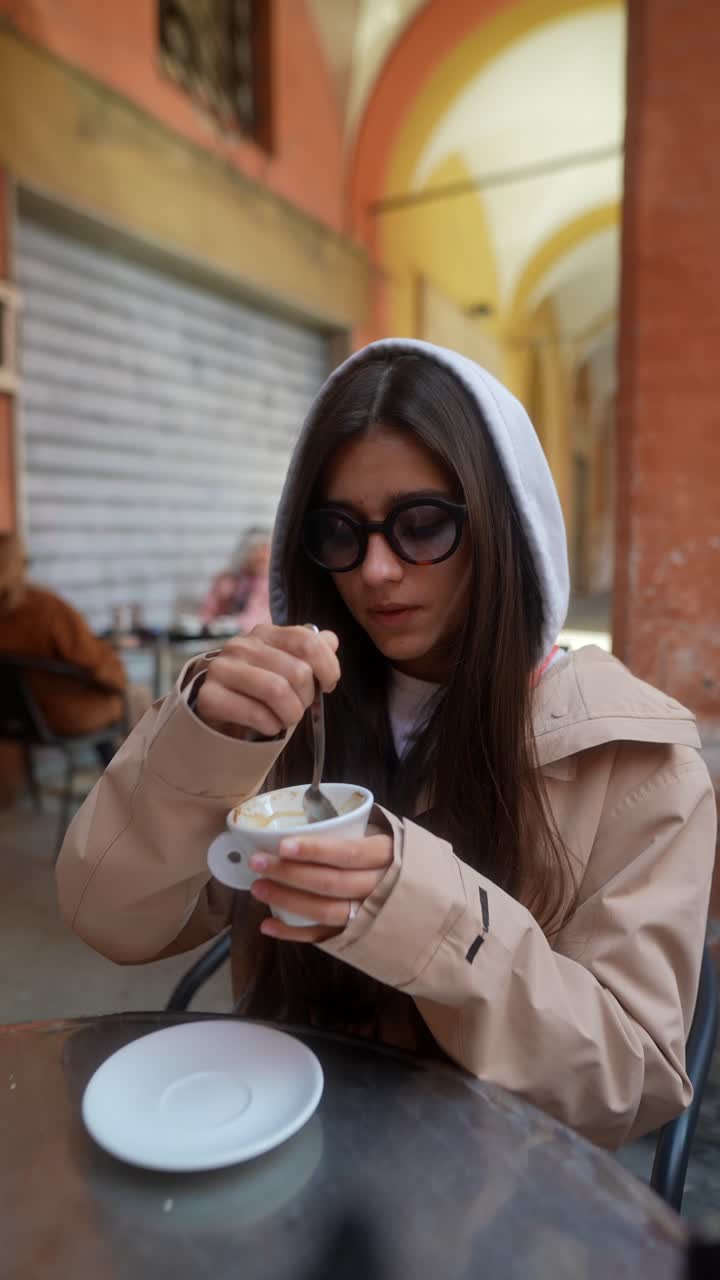 Woman enjoying coffee in a European outdoor cafe