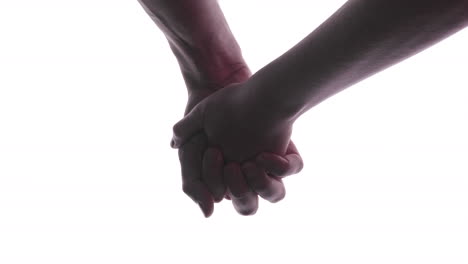 couple holds hands - a man and a woman holding hands with their fingers interlocked - close up, studio shot