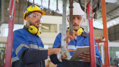 ingeniero con casco de seguridad y gafas de pie en la producción de la fábrica de fabricación. elegir la llave y comprobar el tamaño. concepto industrial y de limpieza. trabajo feliz y buen lugar de trabajo