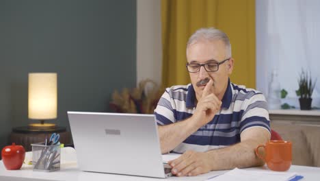home office worker old man says shhh to camera.